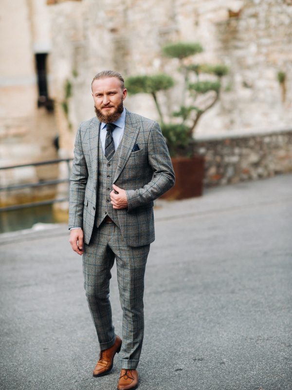 a-man-with-a-beard-in-a-strict-grey-three-piece-suit-with-a-tie-in-the-old-town-of-sirmione-a.jpg